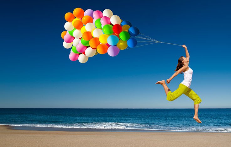 Hypnose-Coaching: Frau mit Ballons am Strand